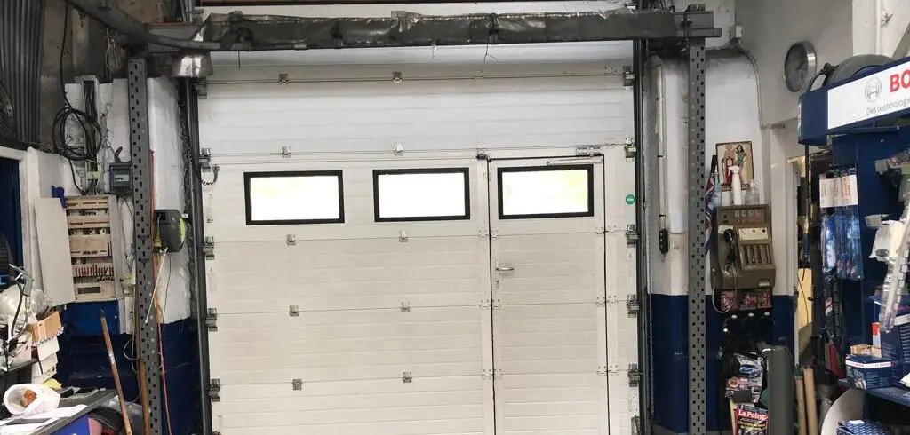 Réparation porte garage sectionnelle à Louvres