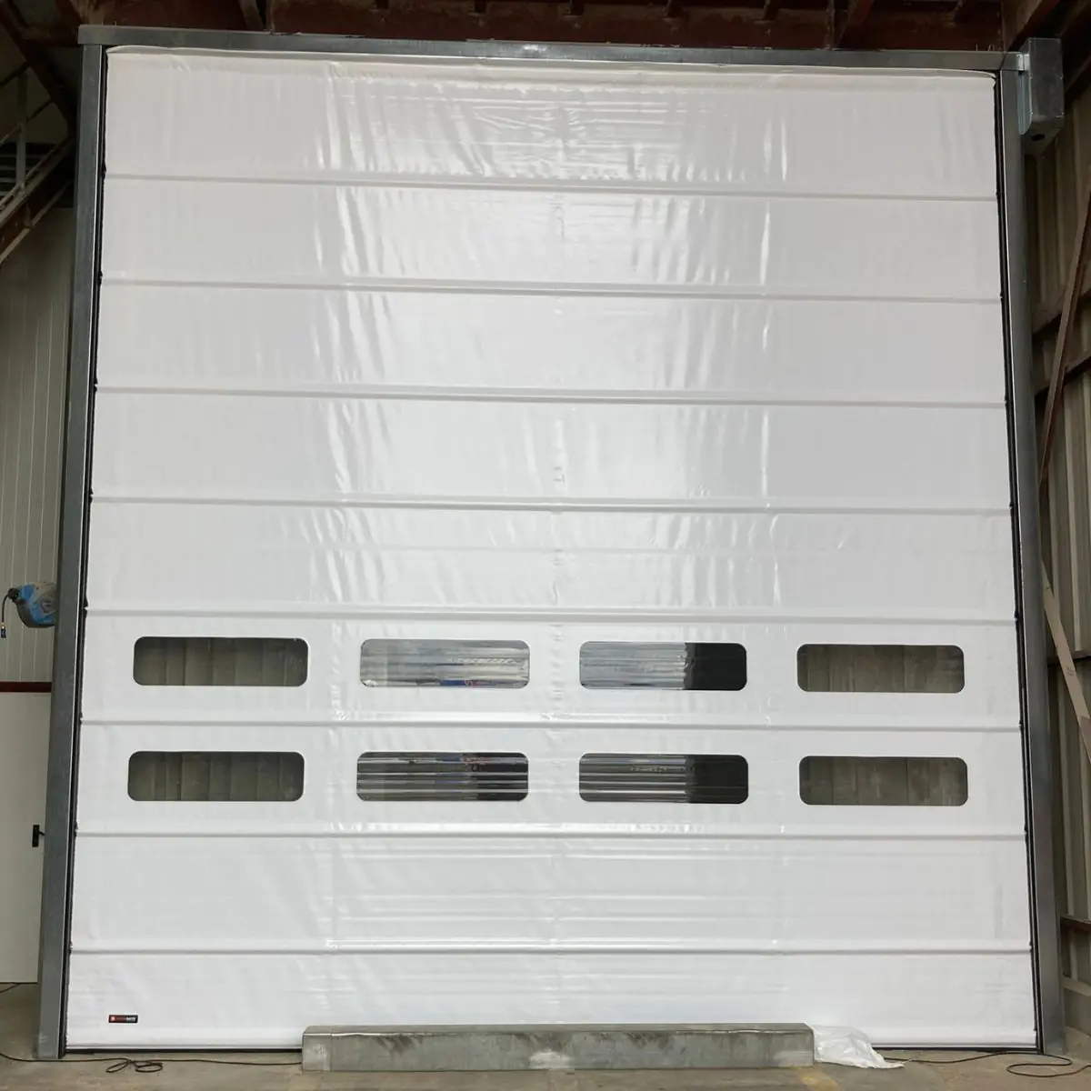 Un problème d’ouverture et de fermeture de portes rapides industrielles freine votre flux logistique ? Ne procrastinez pas ! Sollicitez METAL 2000 sans tarder au 09 72 10 19 19 pour un service de maintenance porte souple rapide Nanterre, rentable et performant ! Nos techniciens agréés travaillent d’arrache-pied pour redonner toute sa splendeur et sa fluidité à votre porte souple rapide. Nos serruriers procèdent à une inspection porte industrielle pointue : ils passent au crible le tablier, le système d’enroulement, les sangles de levage et les capteurs de sécurité. Une défaillance mécanique ou électrique a été détectée lors du passage de notre expert en entretien ? Dotés d’un outillage de pointe, ils s’appliquent au remplacement des éléments détériorés par des pièces détachées pour portes industrielles de qualité.