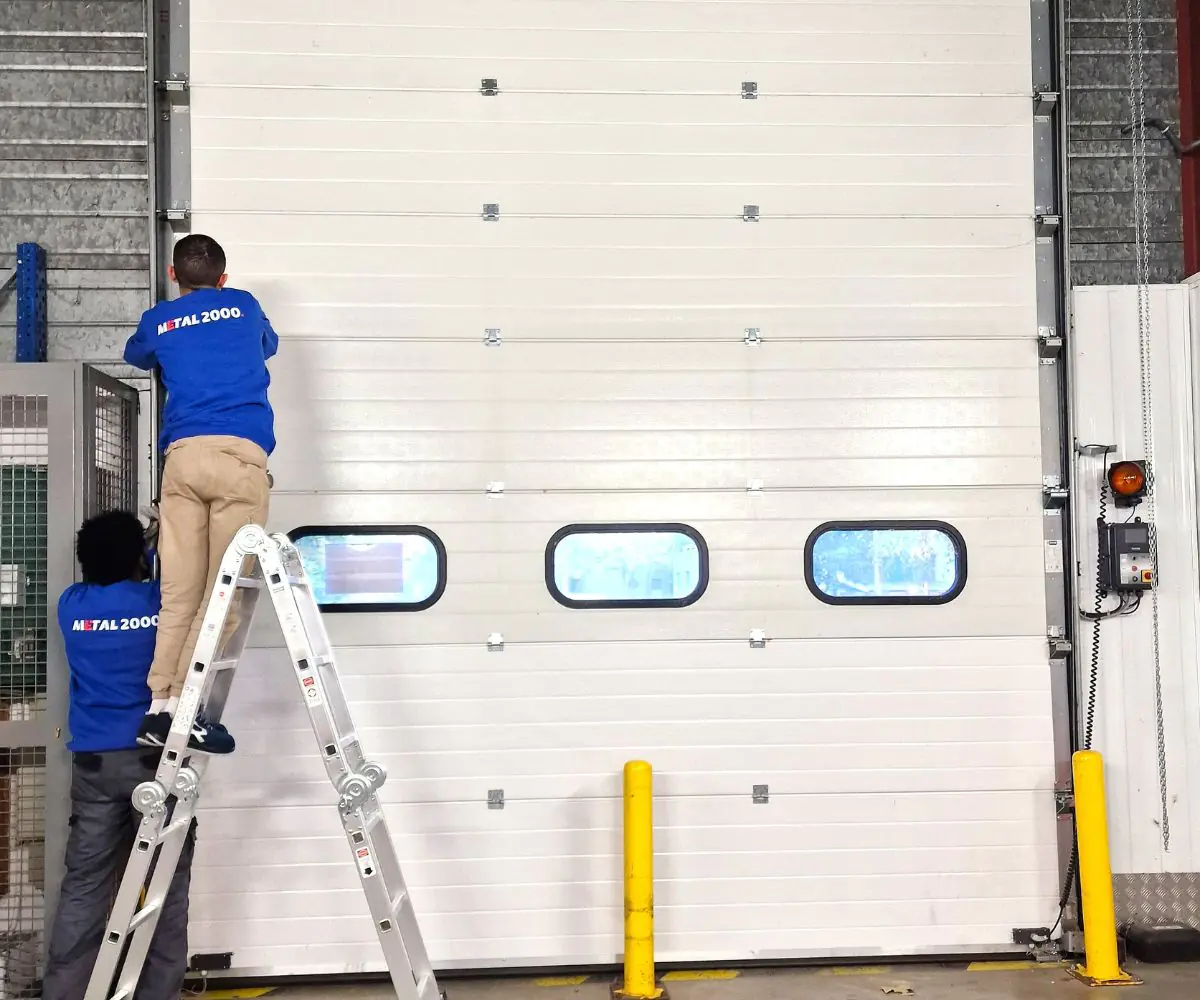Réparation porte sectionnelle industrielle bloquée Falaise
