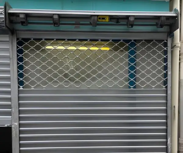 Protection vitrine commerce avec grille métallique panachée pour sécurité et visibilité