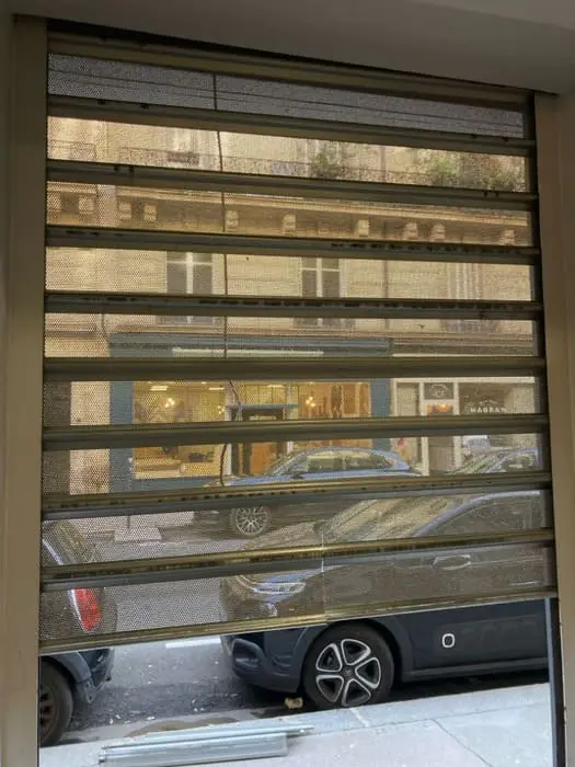 SOS déblocage de rideau métallique bloqué à mi-hauteur devant la vitrine d'une boutique à Paris 18