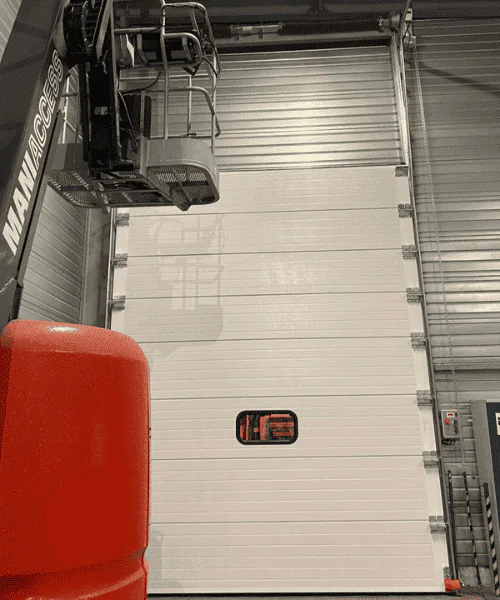 Réparation porte sectionnelle industrielle à Courcy