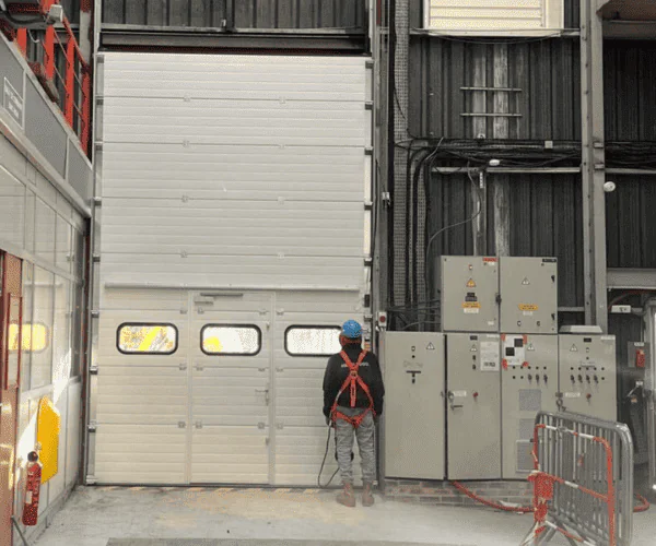 Réparation porte sectionnelle industrielle bloquée à Margency